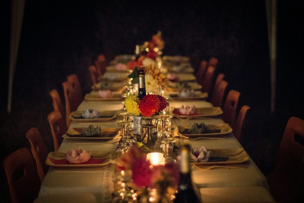 A long dining table set for a dinner party with flowers and candles