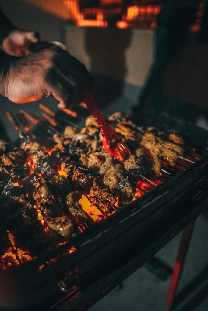 person holding red chili on black pan